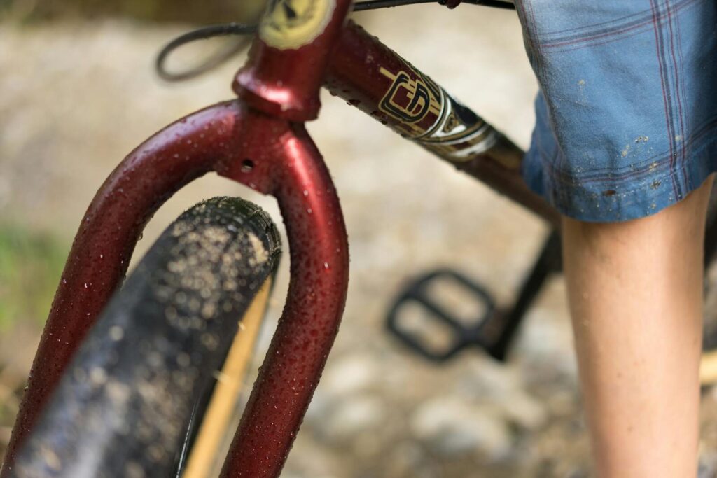 Nærbillede af dækket på et cykelhjul, der er vådt med grus og småsten på