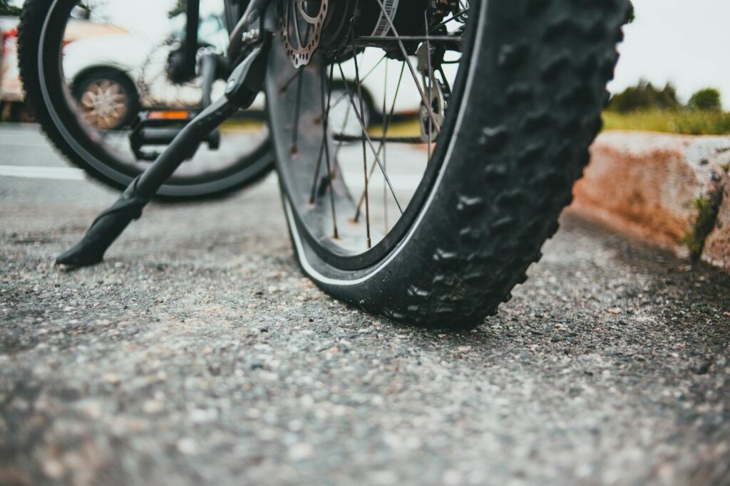 Cykel med et flat dæk står på siden af en vej, da cyklisten ikke kunne undgå punkteringer