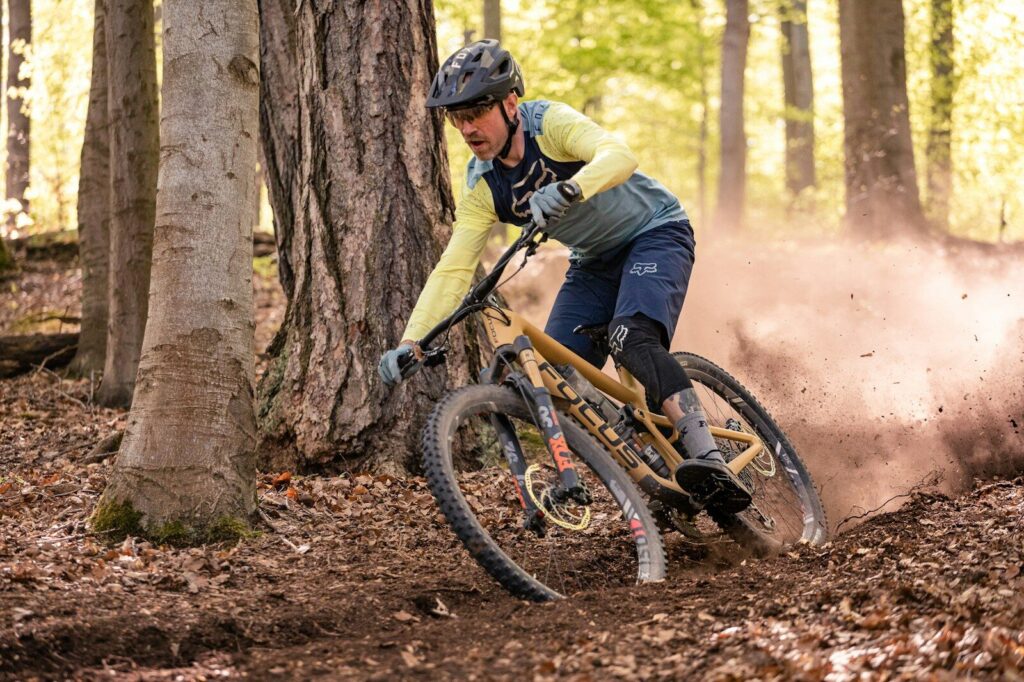 Man med hvid jakke køre på mountainbike i sne med tykke dæk, der passer til situationen