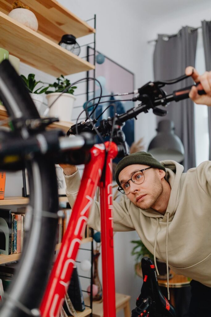 En mand med briller inspirere og tjekker en brugt cykel indendørs.