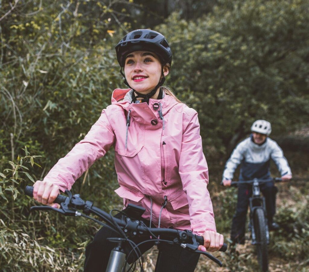 En kvinde med regntøj cykler