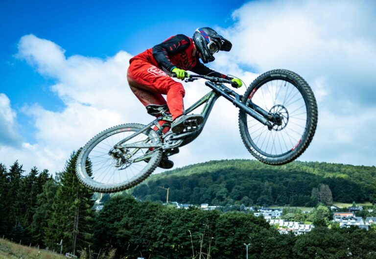 Mand er midt i et hop på downhill cykel